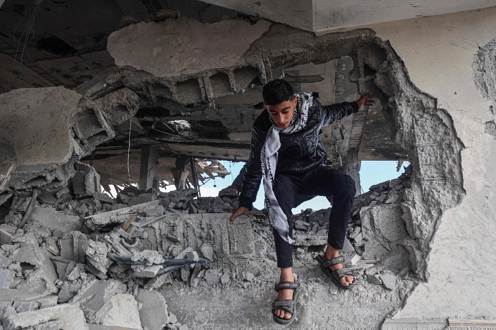 Joven palestino observa los daños a una vivienda tras un bombardeo israelí en Gaza. Foto Afp