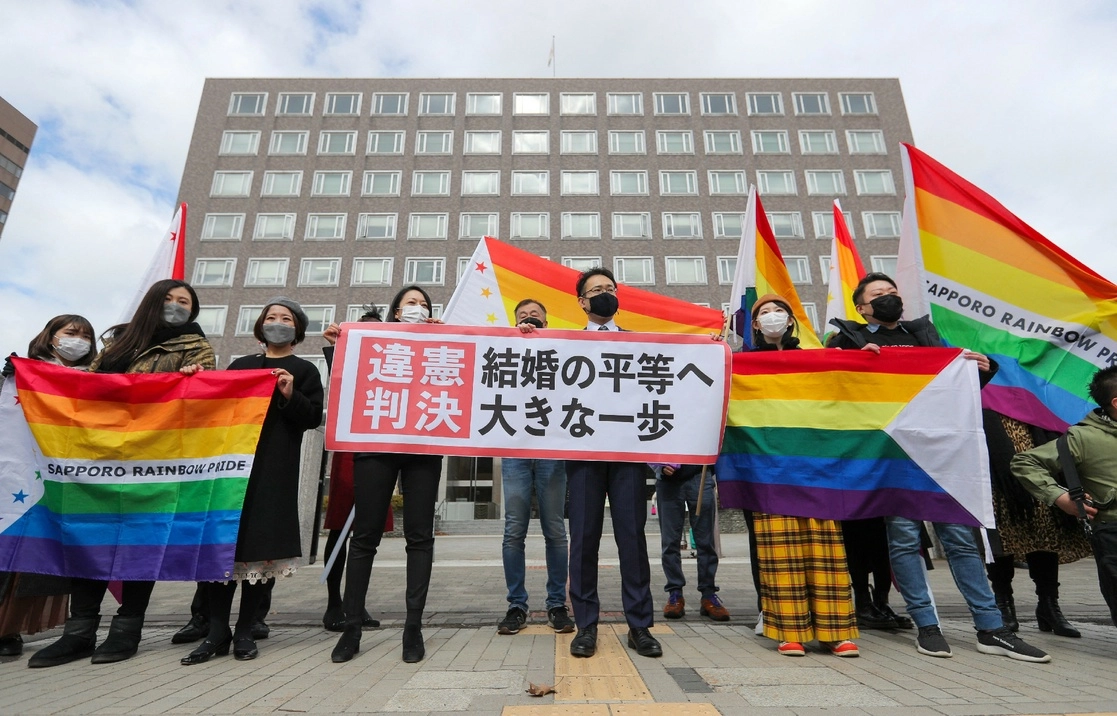 Abogados de los demandantes y activistas por la equidad de derechos ondean banderas arcoiris en las inmediaciones del tribunal de Sapporo, Japón, el 17 de marzo de 2021. Foto Afp