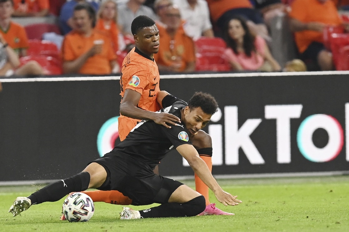Konrad Laimer de Austria y Denzel Dumfries de Holanda caen al suelo al disputar el esférico en duelo la fecha dos de la Eurocopa 2020. Foto Ap