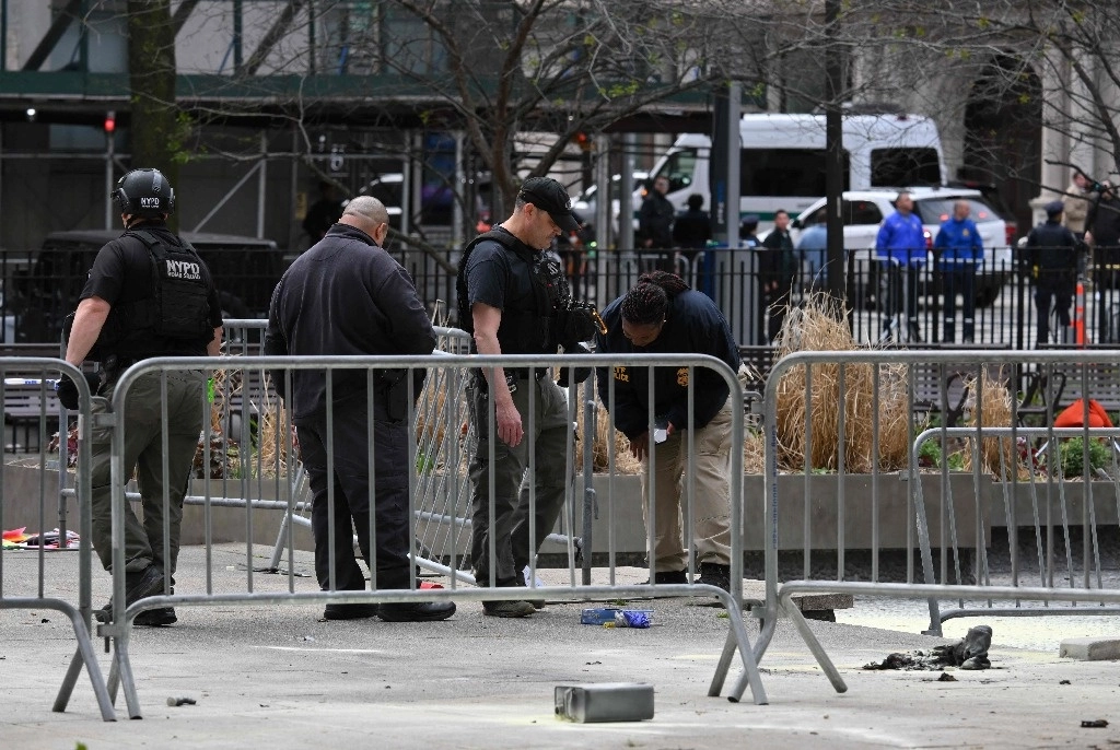 Los investigadores inspeccionan el sitio en el parque frente al Tribunal Penal de Manhattan en la ciudad de Nueva York después de que, según informes, un hombre se prendió fuego durante el juicio del ex presidente estadunidense, Donald Trump, el 19 de abril de 2024. Foto Afp