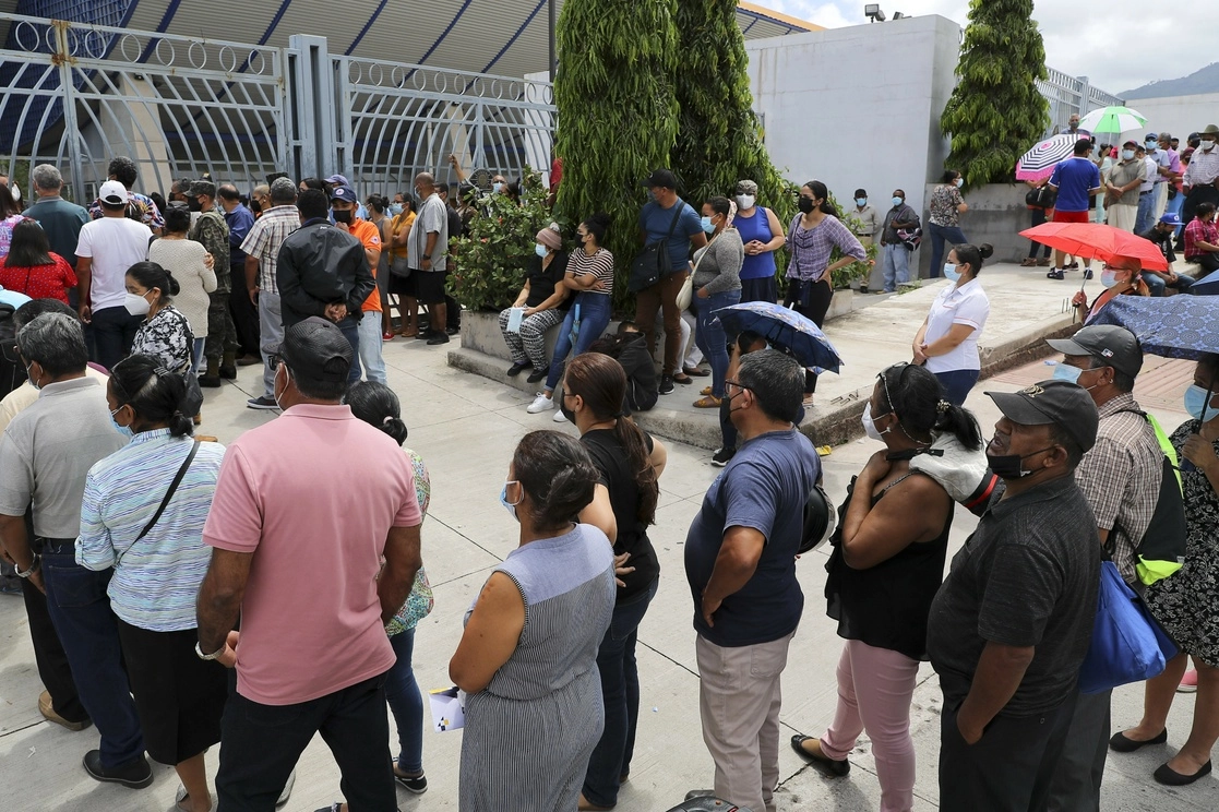 Distintas personas en Tegucigalpa hacen fila para recibir su primera dosis de la vacuna anticovid. Foto Xinhua