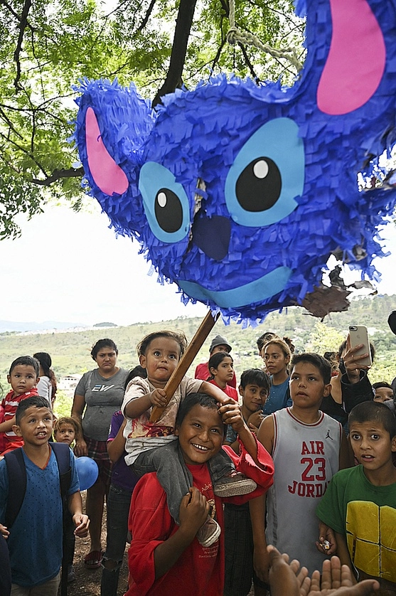 Niños rompen una piñata en Tegucigalpa. Foto Afp