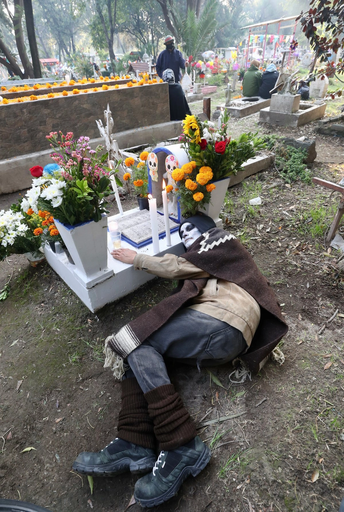 Cientos de personas pasaron la noche del primero al 2 de noviembre junto a las tumbas de sus seres queridos envueltas con cobijas y doble capa de suéteres. En estas imágenes, el panteón Xilotepec, en la alcaldía Xochimilco.