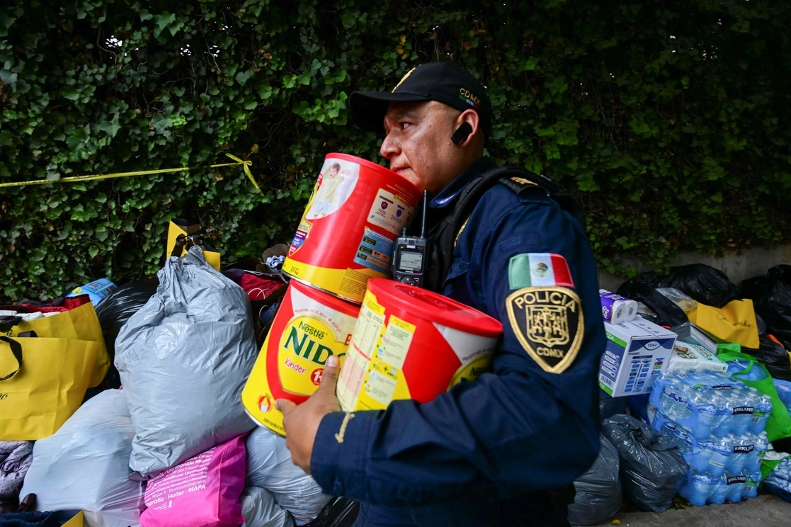 Un policía acomoda donaciones para los afectados por el terremoto en Siria y Turquía, en la embajada turca en la Ciudad de México, en imagen del 9 de febrero pasado. Foto Afp 
