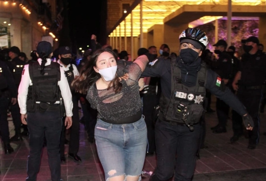 Una joven es detenida por una policía de la capital de Aguascalientes en la Plaza de la Patria, luego de causar disturbios en la marcha por el Día Internacional de la Mujer, la noche del lunes. Foto Claudio Bañuelos