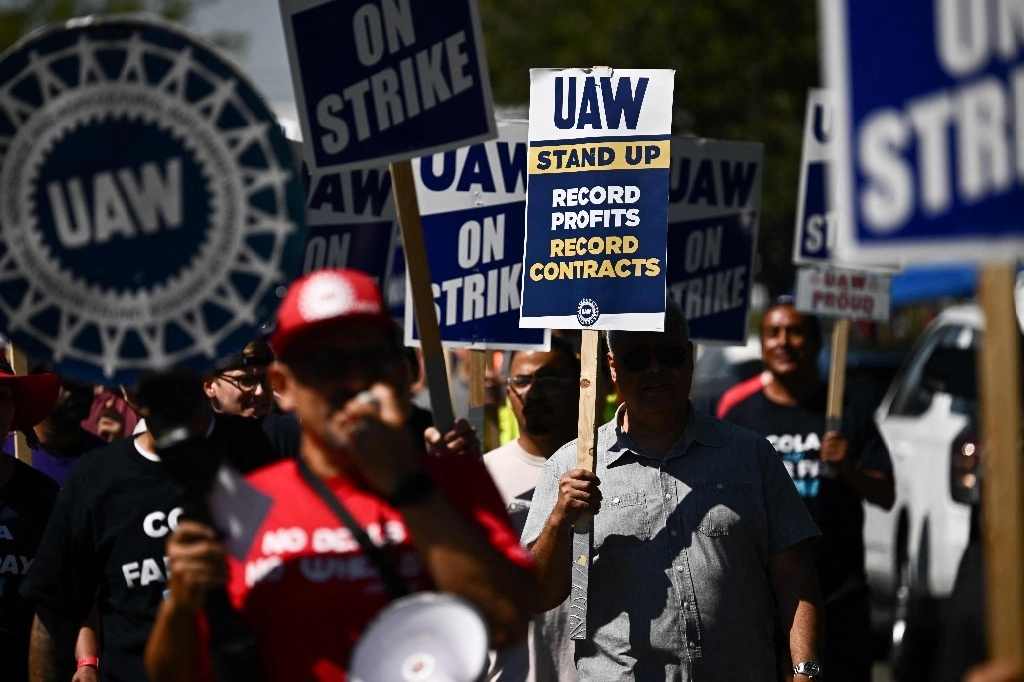 Integrantes del sindicato United Auto Workers (UAW) marchan frente al Centro de distribución de piezas de Stellantis-Chrysler en Los Ángeles, California. Foto Afp