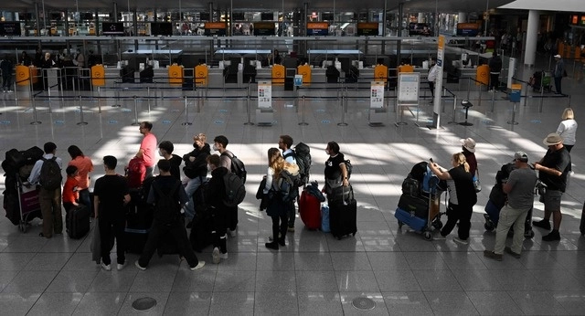 Pasajeros hacen fila frente a los mostradores de la terminal de Lufthansa del aeropuerto Franz-Josef-Strauss de Munich. Foto Afp