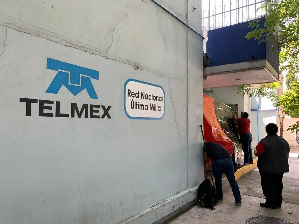 Trabajadores de Telmex colocan banderas de huelga en instalaciones de la empresa en su edificio central ubicado en la colonia del Valle, en la alcaldía Benito Juárez, en la Ciudad de México, el 21 de julio de 2022. Foto Alfredo Domínguez


