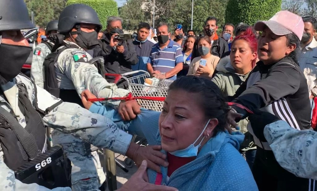 Familiares de un menor desaparecido durante el accidente de la Línea 12 del Metro ocurrido la noche del lunes forcejearon con elementos de la Guardia Nacional para exigir información sobre el paradero del infante. Foto Alfredo Domínguez