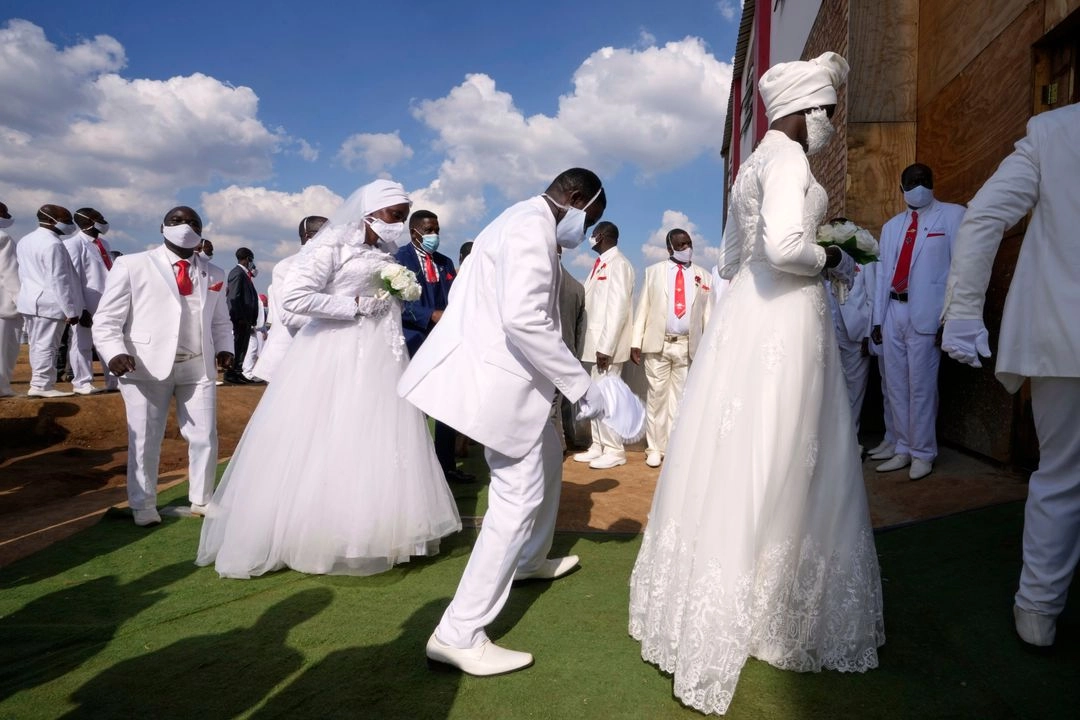 Parejas bailan al entrar a la iglesia durante las bodas de Pascua para 3 mil personas, algunas polígamas, en la Iglesia Internacional de Santidad Pentecostés, en Heidelberg, al este de Johannesburgo, Sudáfrica, el domingo 20 de abril de 2025. 