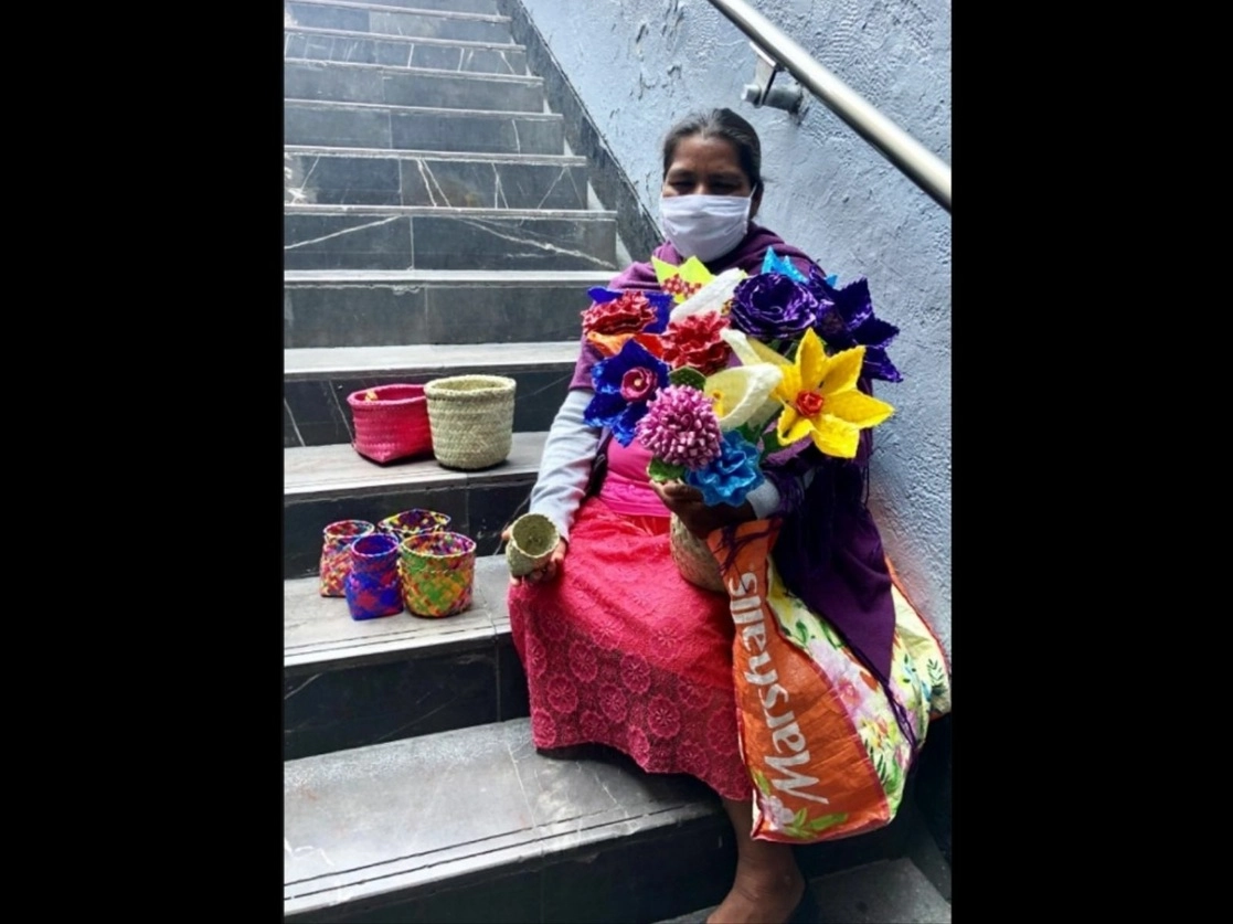 Una indígena vende productos artesanales en una de las escalinatas de salida de la estación Hidalgo del Metro, durante la contingencia de Covid-19. Foto Luis Castillo / Archivo