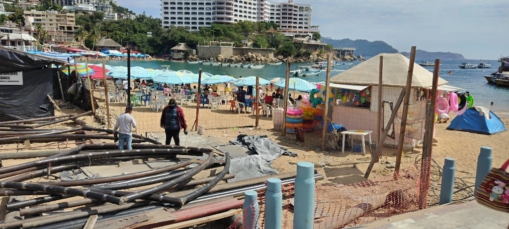 En recorrido en por esta emblemática playa, se observó a vendedores tolerados que ofrecen variedad de productos comestibles en la franja de arena, material de construcción sobre el nuevo puente y accesos a la playa obstruidos aún, también por el material de obra que no ha sido retirado tras la reconstrucción del puente, el cual une las playas de Caleta y Caletilla con el islote de Caleta. Foto Héctor Briseño 