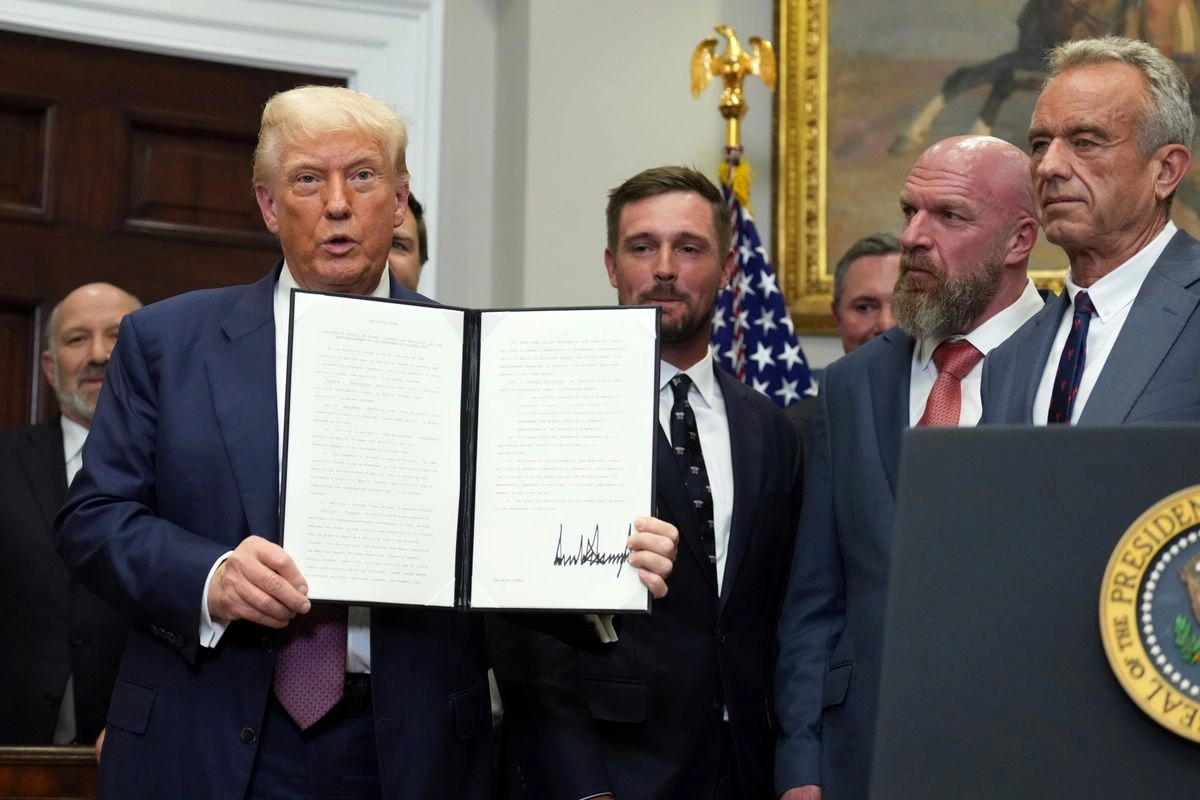 El presidente Donald Trump sostiene una orden ejecutiva firmada este 31 de julio de 2025. Foto