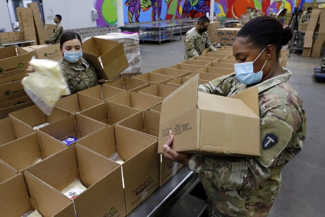 Soldados de la Guardia Nacional preparan cajas de víveres en Texas. Foto Ap