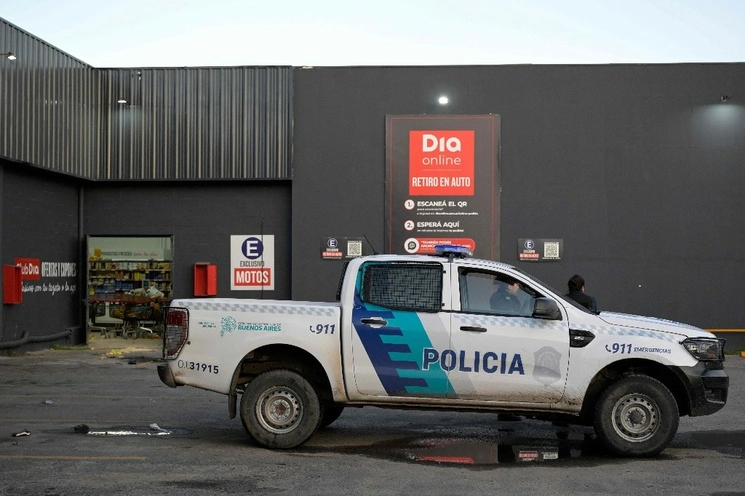 La policía de la provincia de Buenos Aires resguarda uno de los supermercados saqueados a través de acciones impulsadas en redes sociales, como dieron a conocer autoridades provinciales y federales. Foto Afp.