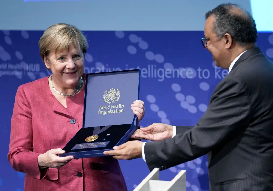 La canciller alemana, Angela Merkel, recibe el 'Premio al Liderazgo Global de la OMS' del director general del organismo, Tedros Adhanom Ghebreyesus, durante la ceremonia de inauguración del Centro de la OMS para Pandemias y Epidemias Intelligence en el edificio Langenbeck-Virchow en Berlín, Alemania, el 1 de septiembre de 2021. Foto Ap