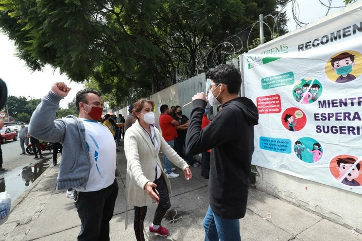 Un adolescente sale del Conalep, ubicado en Coyoacán, donde presentó el examen para ingreso al bachillerato de la Comipems y es recibido por sus padres en la vía pública. Foto María Luisa Severiano