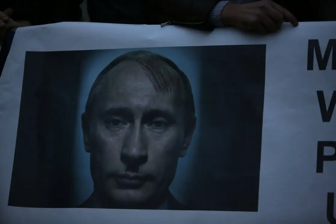 Un manifestante sostiene un cartel con una foto del presidente ruso, Vladimir Putin, durante una protesta frente a la embajada rusa en Lisboa, el jueves 24 de febrero de 2022. Foto Ap 