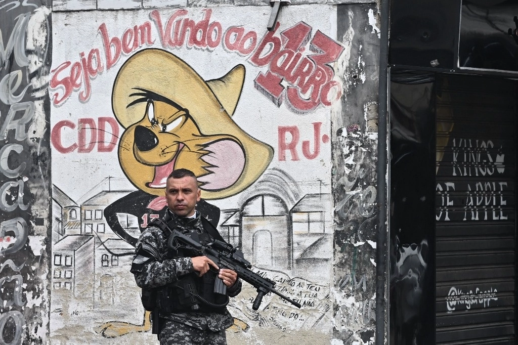 Un policía militar patrulla una calle en la favela Ciudad de Dios, en la zona oeste de Río de Janeiro, Brasil, el 15 de julio de 2024. Foto Afp