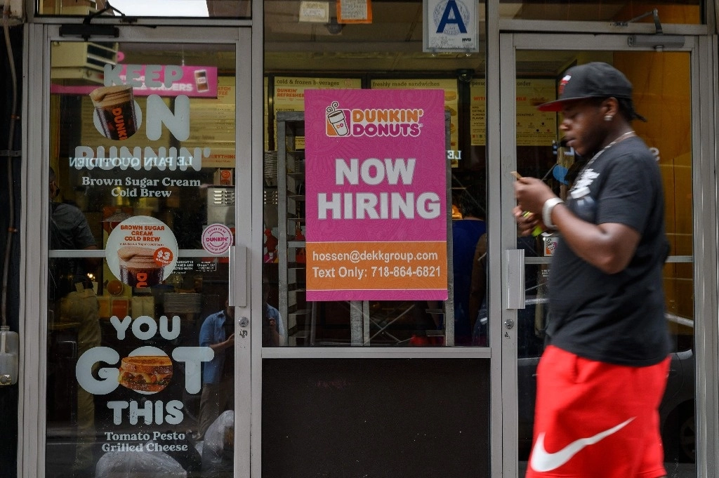 Un hombre pasa junto a un cartel de "Se busca personal" en la ciudad de Nueva York el 8 de julio de 2022. El mercado laboral estadounidense probablemente estuvo más frío de lo esperado en el año hasta marzo, según mostraron los datos del Departamento de Trabajo al 21 de agosto de 2024, lo que indica un crecimiento más débil pero aún positivo. Foto Afp