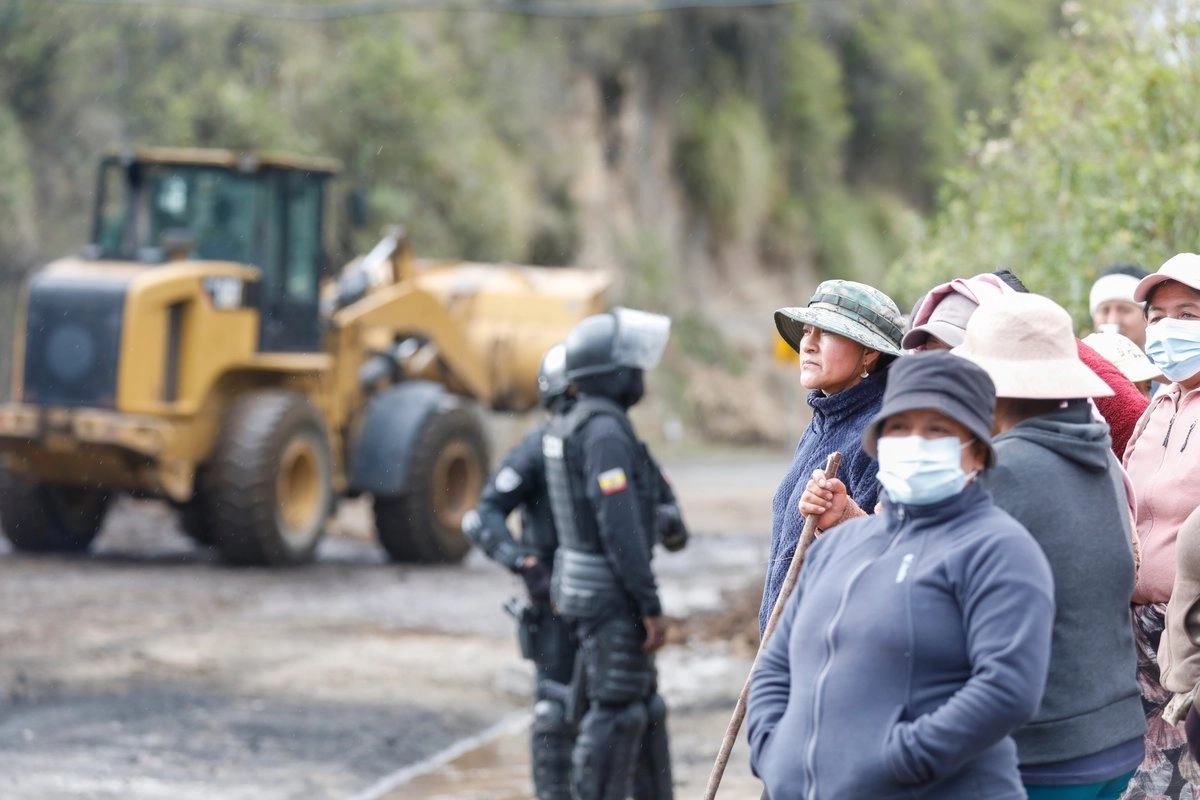 Mujeres indígenas observan a los elementos de la policía abrir la circulación en la vía Tabacundo-Cajas, en la comuindad de Pichincha, luego que se anunció el fin de las movilizaciones de la Confederación de Nacionalidades Indígenas de Ecuador (Conaie), el 22 de octubre de 2025. Foto 