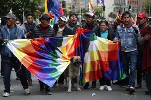 En imagen de archivo, manifestantes sostienen una whipala, bandera que representa a los pueblos originarios de Bolivia. Foto Ap