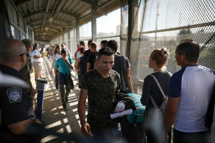 Migrantes hacen fila en el puente Puerta México, en Matamoros, Tamaulipas para solicitar asilo a Estados Unidos. Foto Ap/Archivo