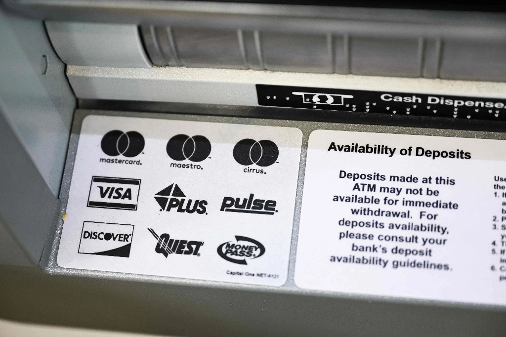 Los logotipos de las redes de pago Discover, Visa, Mastercard, Maestro, Cirrus, Plus, Pulse, Quest y MoneyPass se muestran en un cajero automático. Foto Afp
