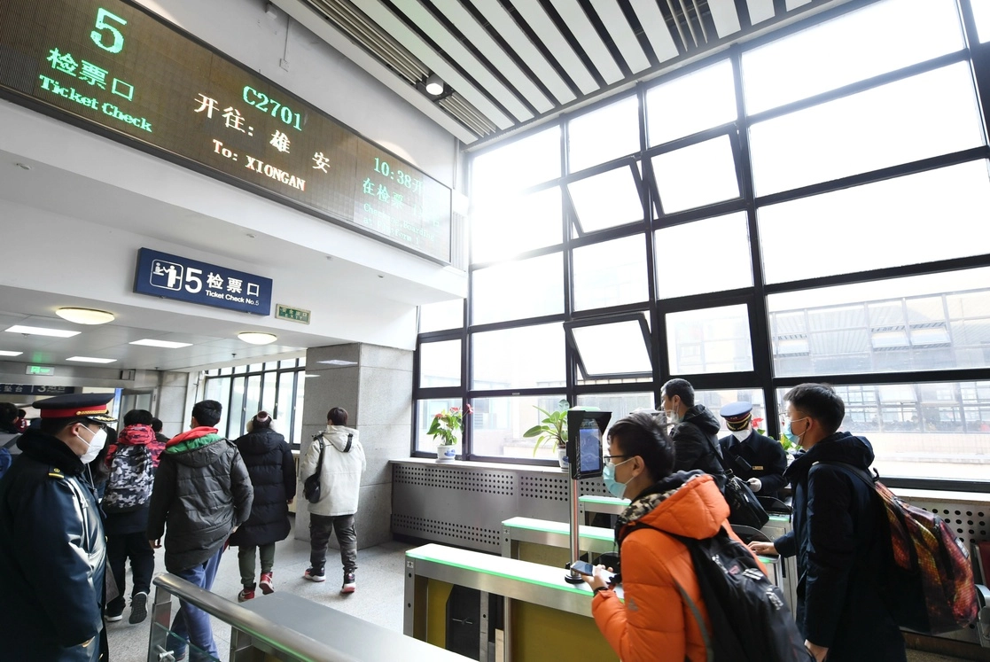 Pasajeros caminan para abordar un tren bala con destino a Xiong'an en la Estación de Ferrocarril de Beijing Oeste. Foto Xinhua