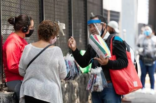 Para superar la falta de ingresos fijos, mexicanos fabrican y venden cubrebocas. La imagen, en la capital del país. Foto Pablo Ramos