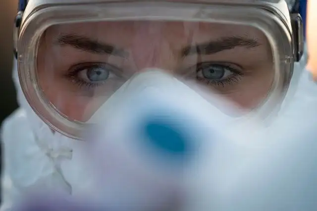 Una trabajadora médica con gogles para protegerse del coronavirus, toma la temperatura a los automovilistas en la frontera entre Eslovenia e Italia. Foto Afp 