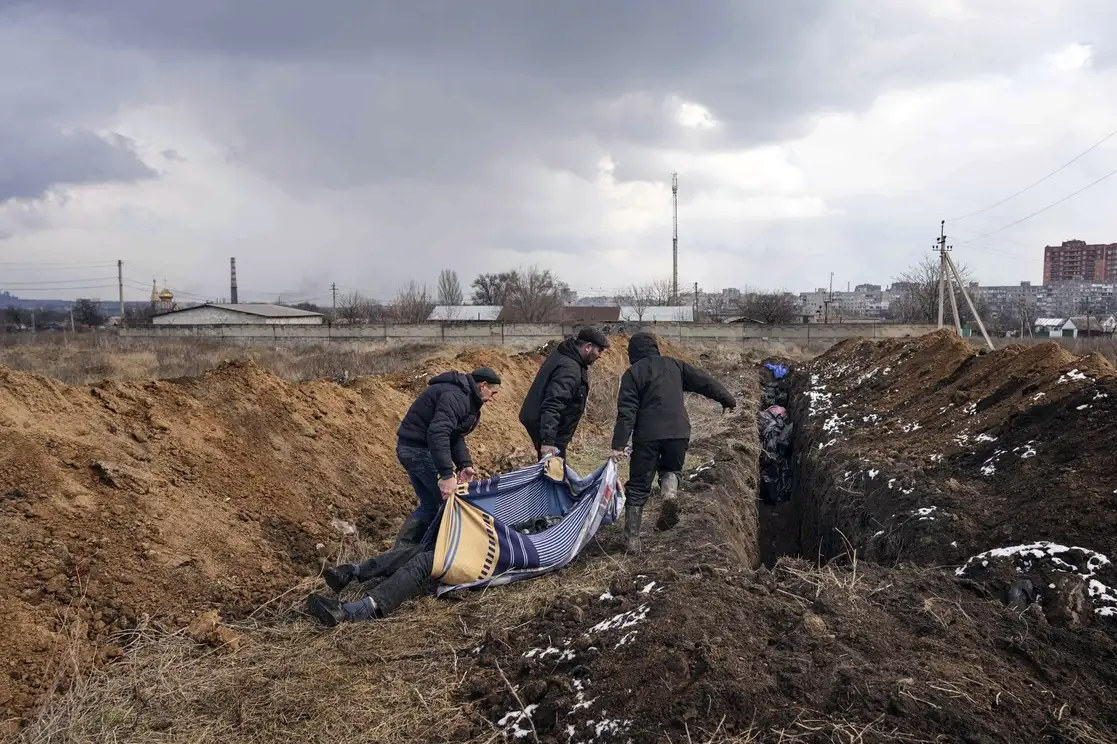 Los cadáveres son colocados en una fosa común en las afueras de Mariupol, Ucrania, el pasado 9 de marzo. Foto Ap
