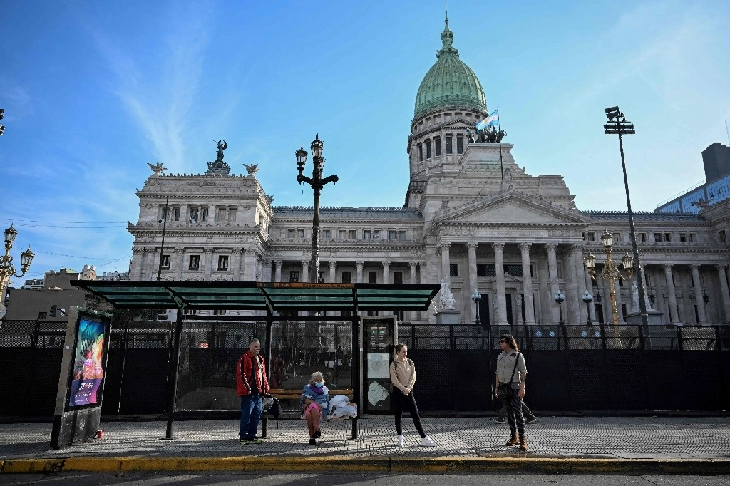 La gente espera el autobús en una estación de autobuses frente al Congreso Nacional en Buenos Aires el 13 de junio de 2024. La inflación mensual en Argentina, asolada por la crisis económica, fue del 4,2 por ciento en mayo, la más baja en dos años y medio. años, debido principalmente a una caída del consumo interno, y la inflación interanual se sitúa en 276.4 por ciento, informó este jueves el instituto de estadísticas INDEC. Foto Afp