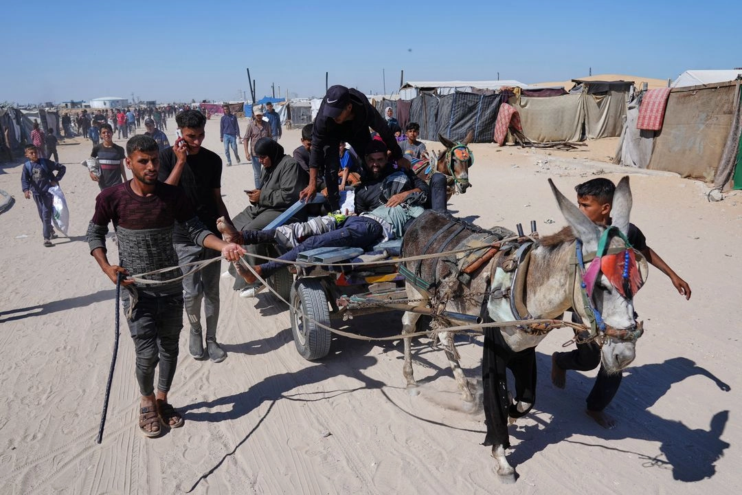 Palestinos cargan a un hombre herido tras recibir un disparo en un centro de distribución de ayuda en Jan Yunis, al sur de la franja de Gaza, el 29 de mayo de 2025. Foto 