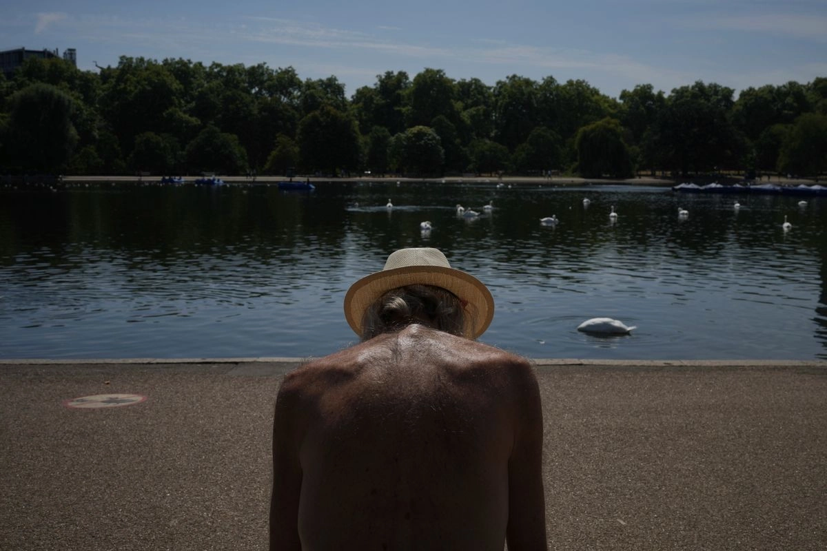 Un hombre se sienta al sol en un parque de Londres mientras partes del Reino Unido enfrenta una ola de calor, el 11 de agosto de 2025. 
