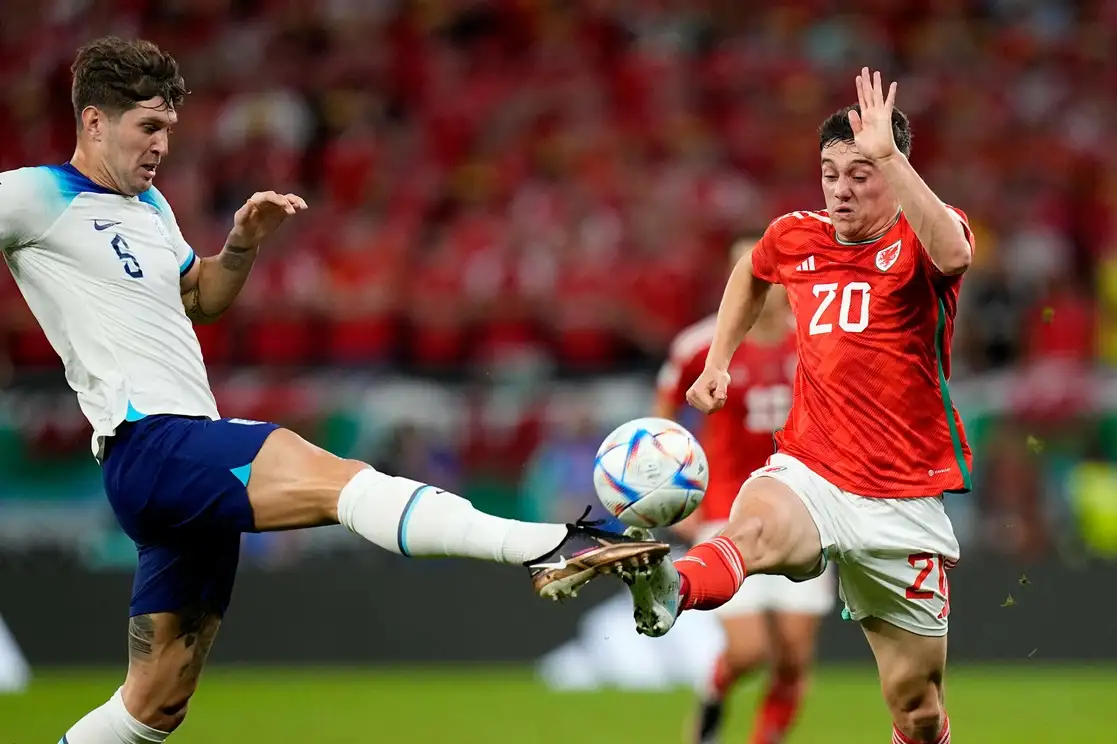 John Stones de Inglaterra, y Daniel James de Gales durante el encuentro del grupo B del Mundial de Qatar, en el estadio Ahmad Bin Ali en Al Rayyan, Qatar, el 29 de noviembre de 2022. Foto Ap