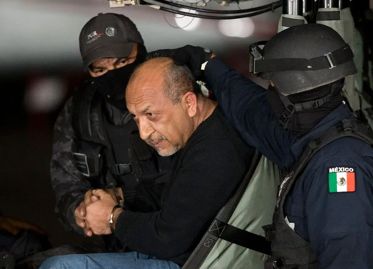 La policía federal mexicana escolta a quien identifican como Servando "La Tuta" Gómez, líder del cártel de los Caballeros Templarios, mientras se encuentra dentro de un helicóptero en un hangar federal en la Ciudad de México, el 27 de febrero de 2015. Foto