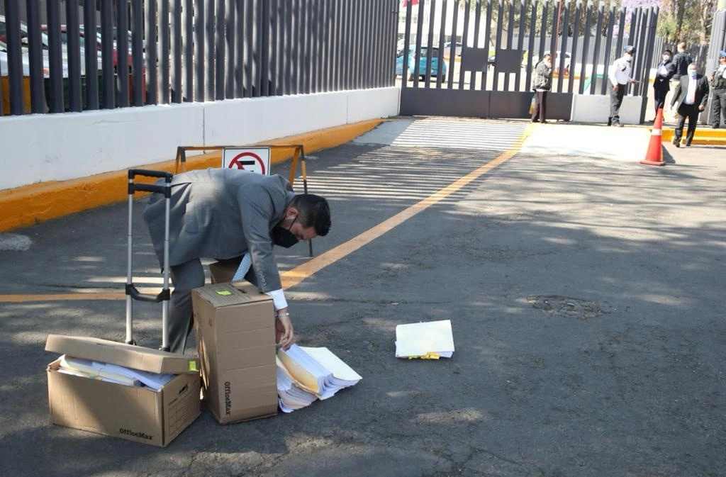 Un trabajador vuelca las cajas con el expediente de Rosario Robles, antes de iniciar su audiencia intermedia en el Reclusorio Sur, en la Ciudad de México, el 26 de marzo de 2021. Foto José Antonio López
