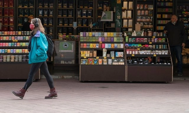 Una joven pasa frente a una tienda vacía en Viena, Austria. Foto Afp 