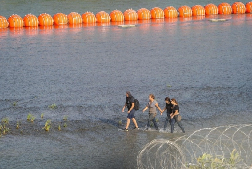 Migrantes caminan junto al Río Bravo, en imagen del 16 de julio de 2023. Foto Afp
