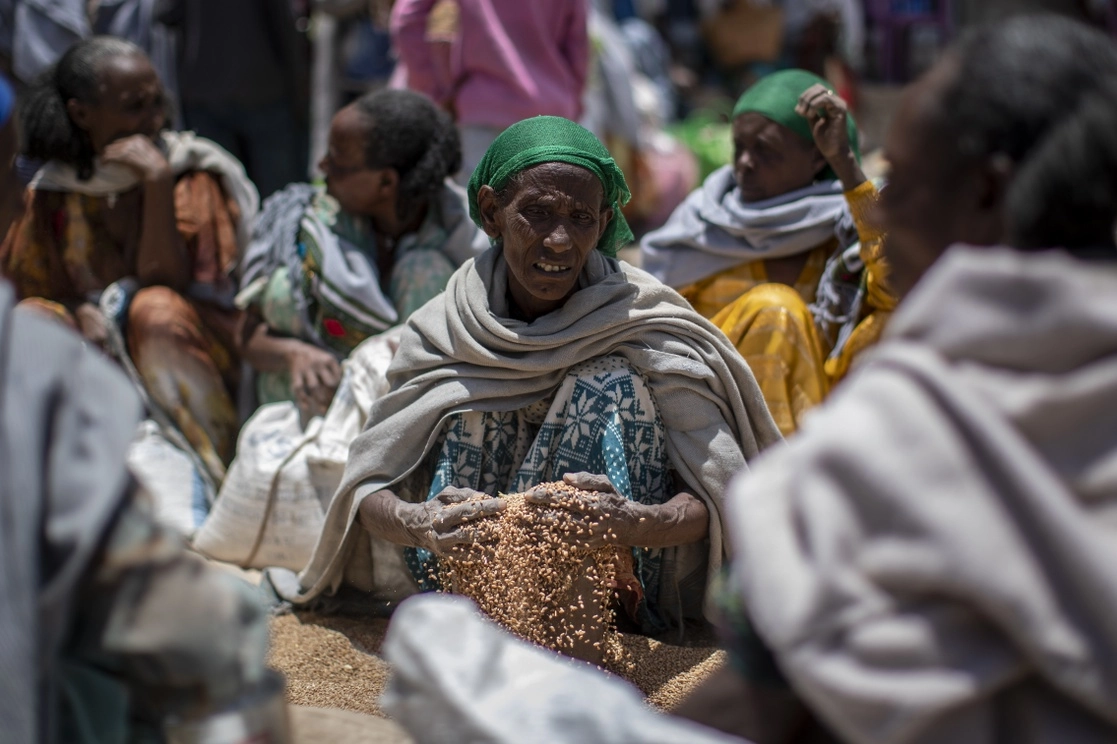 Una mujer sostiene granos de trigo distribuidos en la región del Tigray, en Etiopía. Foto Ap / Archivo