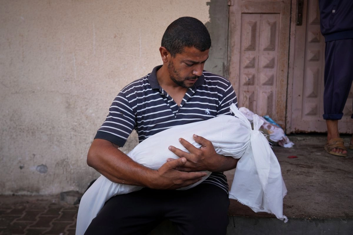 Omar Meshmesh carga el cadáver de su sobrina Aya, de tres años de edad, asesinada junto con al menos otros nueve niños y tres mujeres que esperaban fuera de una clínica en Deir al Balah, en la franja de Gaza.
