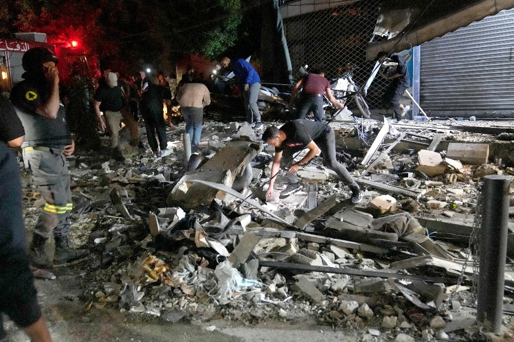 Vecinos retiran escombros de una vivienda bombardeada por Israel en Beirut. Foto Ap 