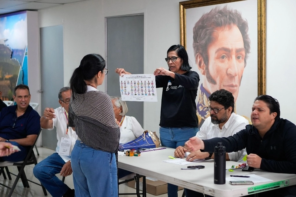 Ciudadana venezolana recibe instrucciones sobre como emitir su voto en la embajada venezolana en Panamá. Foto Afp