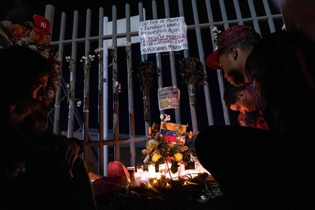 Migrantes encienden velas durante una vigilia afuera de las instalaciones del INM en Ciudad Juárez, Chihuahua. Foto Afp