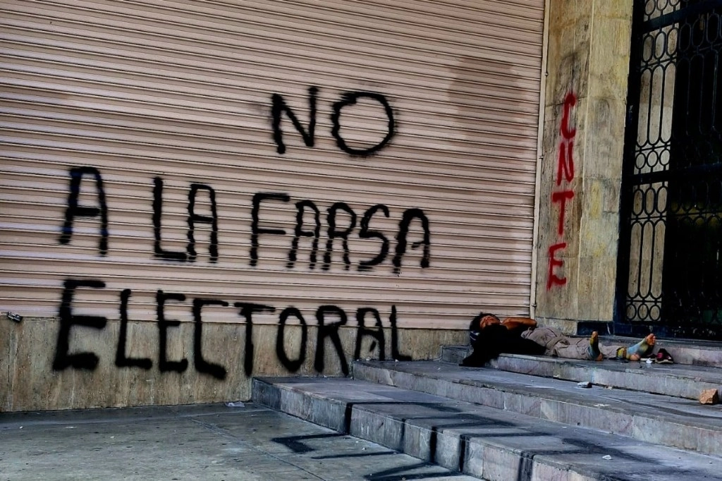 Un mensaje con la frase "No a la farsa electoral" se observa sobre la cortina de un negocio en una calle en Chiapas, el 2 de junio de 2024. Foto Arturo Cano
