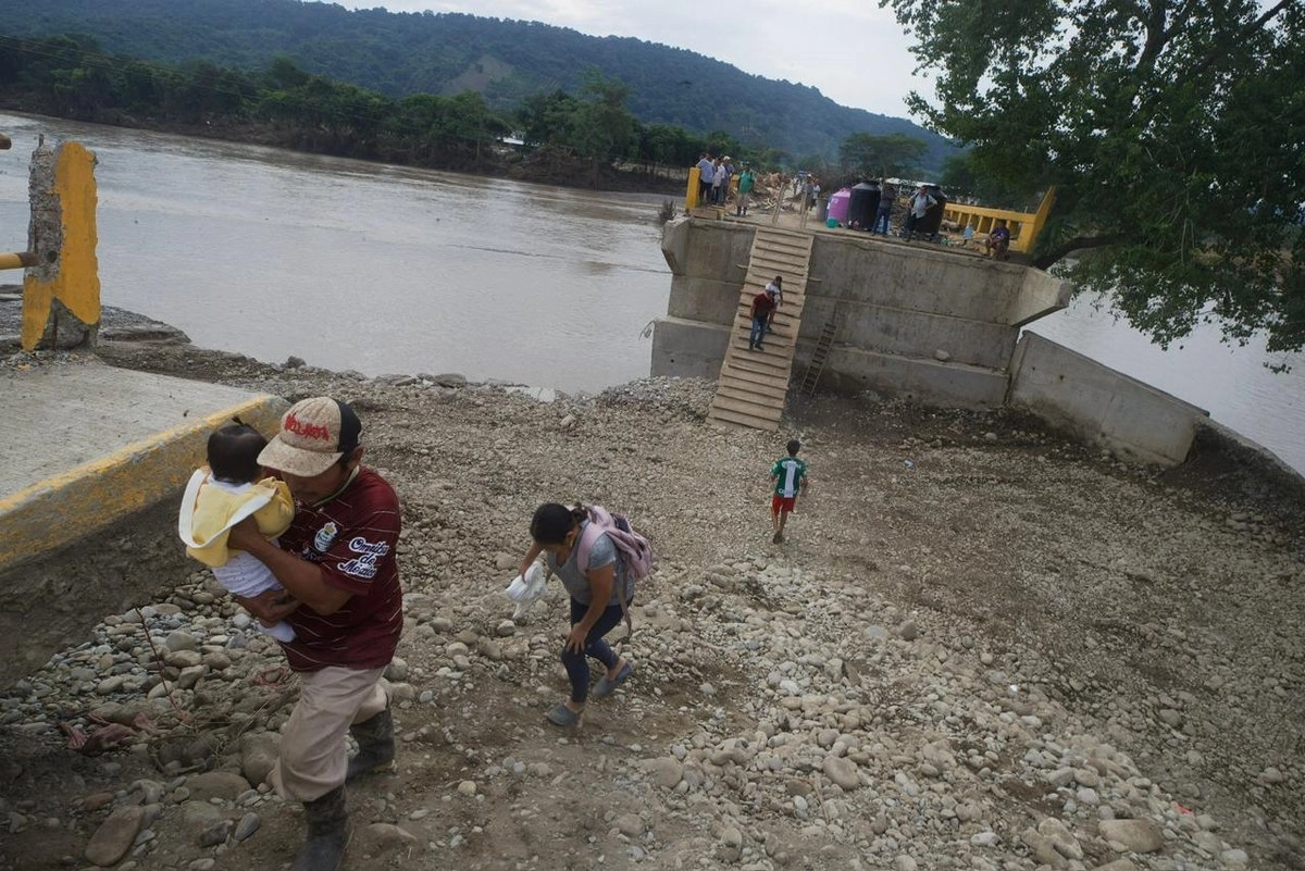 Afectados de la comunidad Aguacate, Veracruz improvisaron una escalera para habilitar el puente que comunica su poblado. Foto