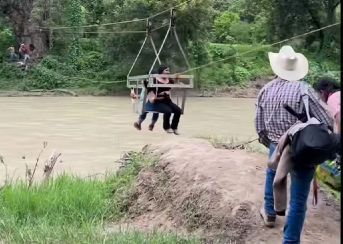 Pobladores de Vado Hondo, en el municipio de Jacala de Ledezma, habilitaron una rudimentaria tirolesa con una canastilla para poder cruzar el río Amajac. Foto 