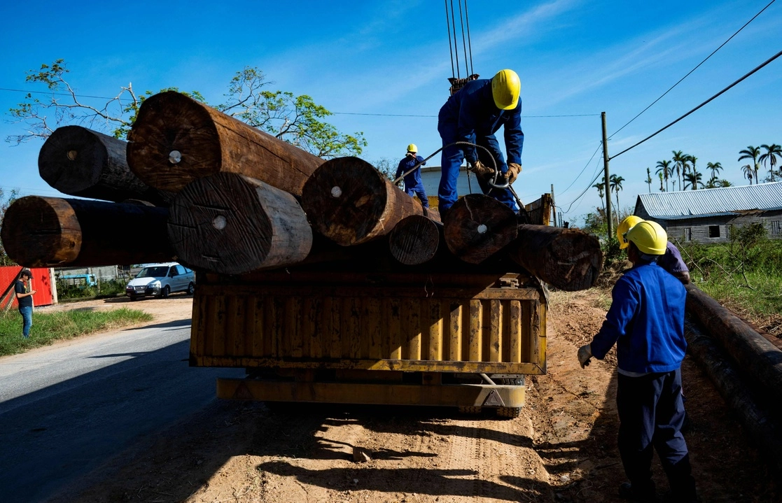 Electricistas cubanos realizan labores de repación del tendido eléctrico en la provincia de Pinar del Río, una de las más afectadas tras el paso del huracán 'Ian'. Foto Afp.