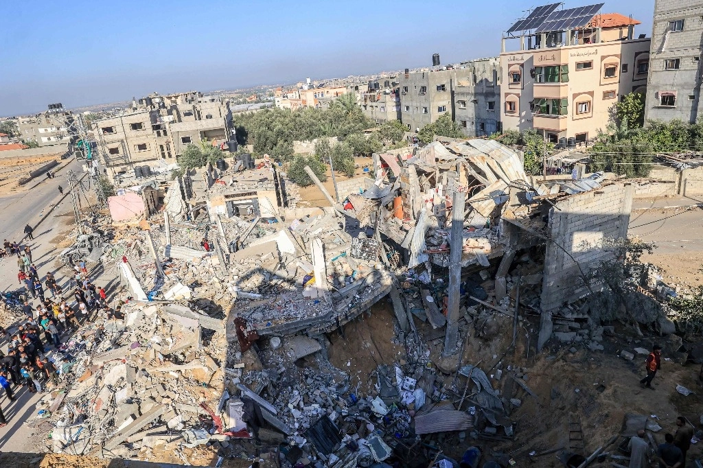 Palestinos buscan supervivientes y víctimas atrapadas bajo los escombros de un edificio tras el bombardeo israelí de Rafah, en el sur de la Franja de Gaza. Foto Afp